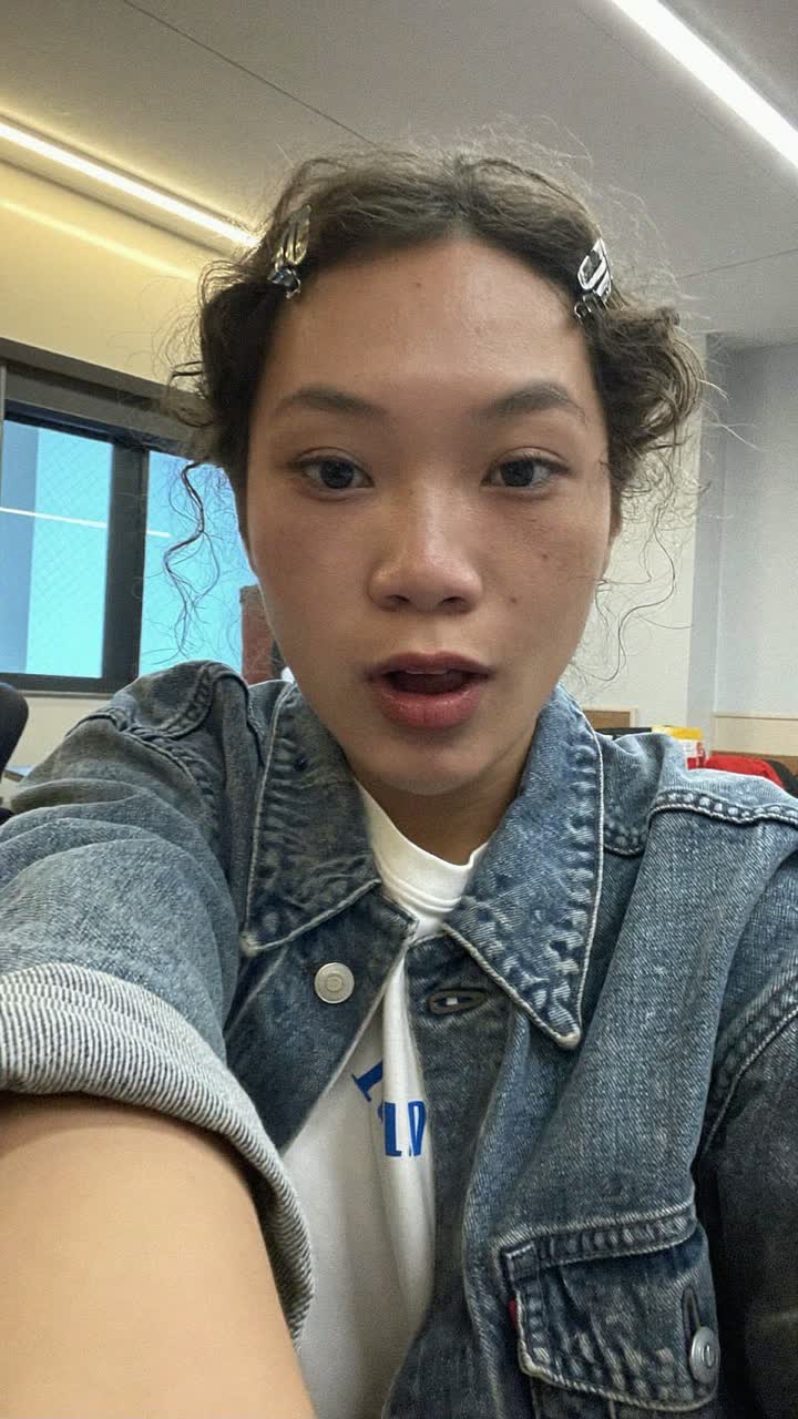 Hana, 35-year-old Japanese woman, loose curls with a claw clip, wearing a denim jacket over a white tee