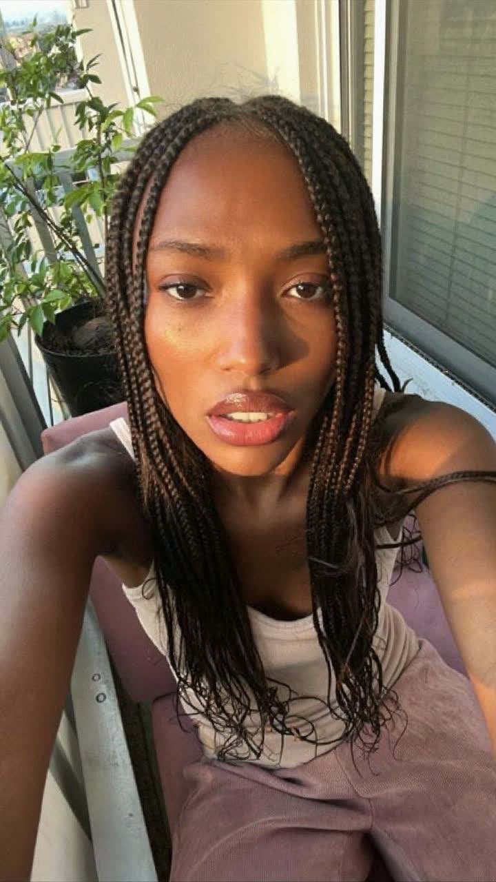 Jasmine, 31-year-old Black American woman, box braids, wearing a soft pink matching lounge set