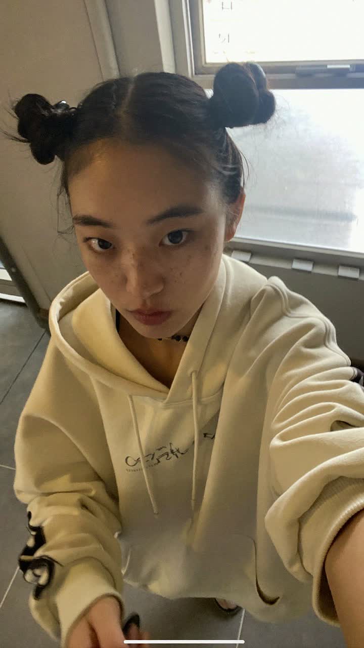 Lily Chen, 28-year-old Chinese woman, space buns, wearing a oversized cream hoodie