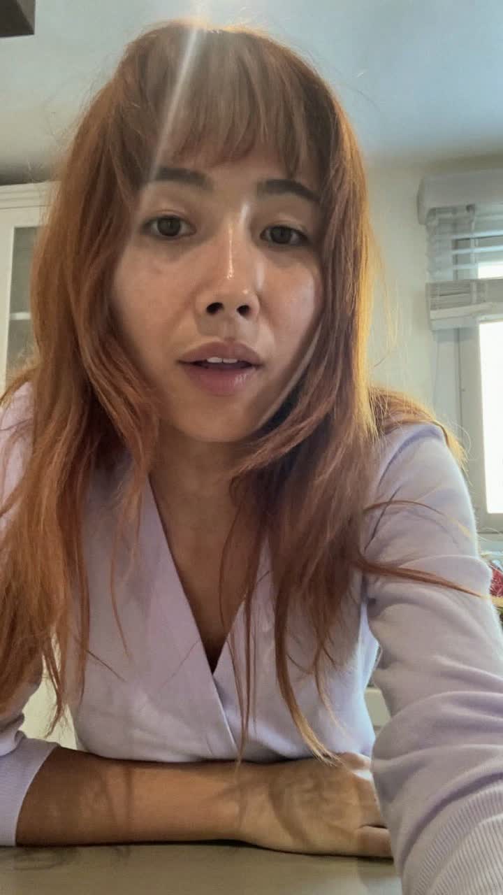 Linh, 35-year-old Vietnamese woman, auburn hair with curtain bangs, wearing a pastel cardigan