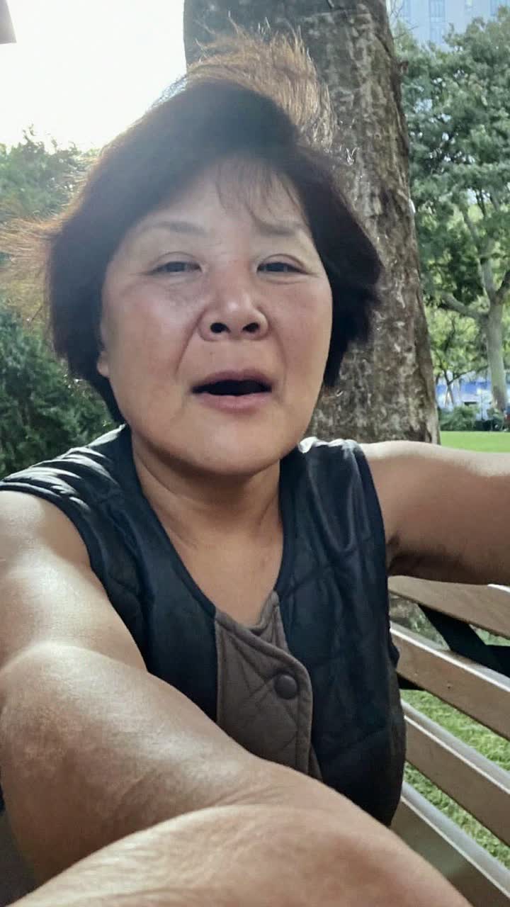 Mei, 58-year-old Chinese woman, short permed black hair, wearing a quilted vest