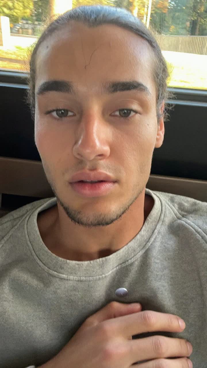 Rafael, 24-year-old Brazilian man, slicked-back hair, wearing a grey crewneck sweatshirt