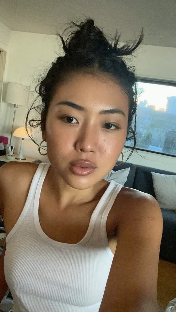 Rin, 29-year-old Japanese woman, messy bun, wearing a white ribbed tank top and gold hoops