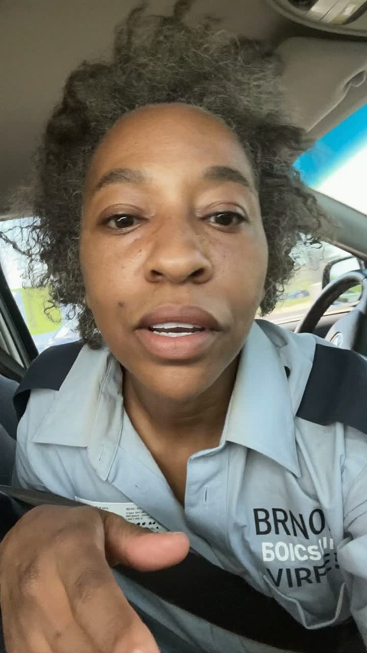 Shanice, 42-year-old Afro-Caribbean woman, natural curls, wearing a bus-driver uniform shirt