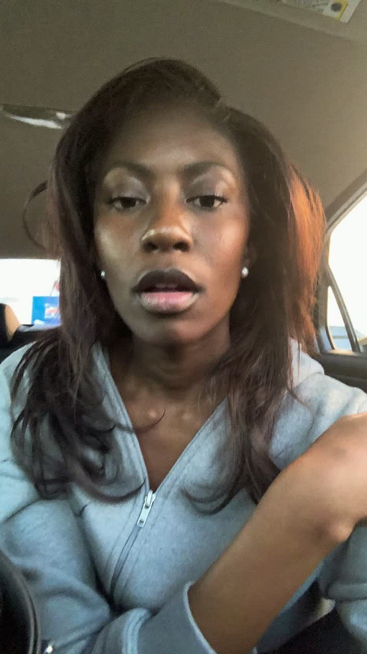 Temi, 35-year-old Nigerian woman, glossy layered hair, wearing a grey zip-up and tiny pearl earrings