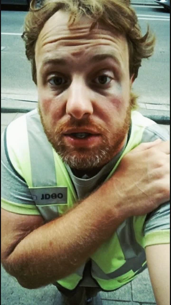 Tom, 38-year-old Irish man, ginger beard, slightly chubby, wearing a hi-vis work vest over a grey tee